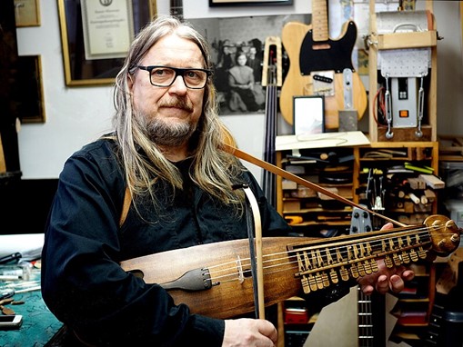 Foto i halvfigur på Rauno Nieminen hållande i instrumentet