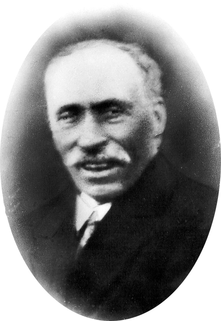 Oskarpt svartvitt fotografi av en oval porträttbild på en man med mustasch.